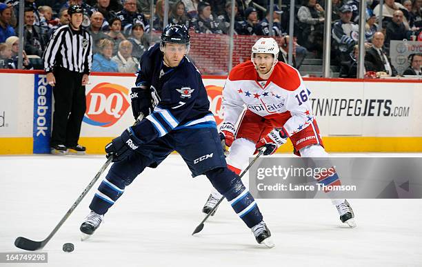 Derek Meech of the Winnipeg Jets plays the puck as Eric Fehr of the Washington Capitals gives chase during third period action at the MTS Centre on...