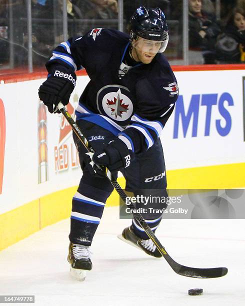 Derek Meech off the Winnipeg Jets plays the puck along the boards during first period action against the Washington Capitals at the MTS Centre on...