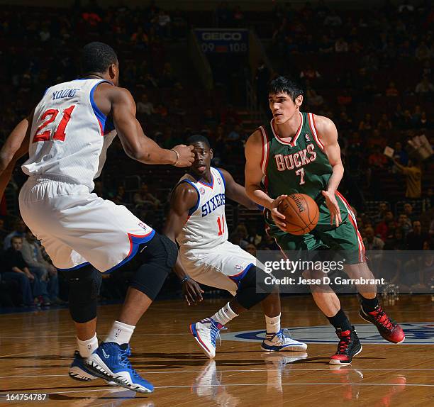 Ersan Ilyasova of the Milwaukee Bucks drives to the basket against Thaddeus Young and Jrue Holiday of the Philadelphia 76ers at the Wells Fargo...