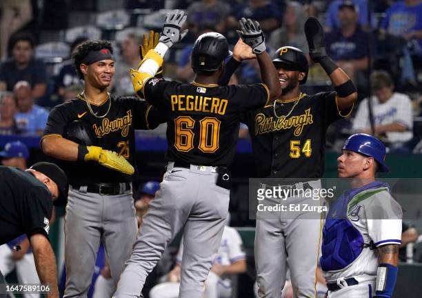 Liover Peguero of the Pittsburgh Pirates celebrates his three-run home run with Endy Rodriguez and Joshua Palacios in the ninth against the Kansas...