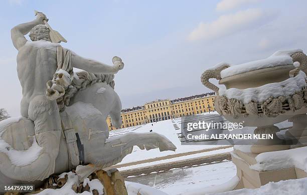 The Palace and gardens of Schoenbrunn are seen through fountain sculptures in snow on March 27, 2013 in Vienna. The Schoenbrunn Palace was the summer...