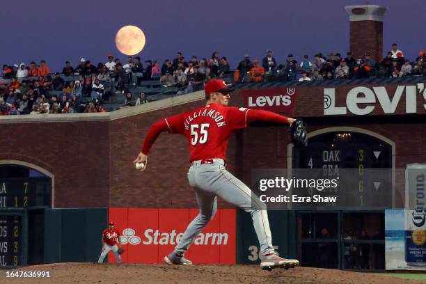 Brandon Williamson of the Cincinnati Reds pitches against the San Francisco Giants while an almost full moon rises behind him in the fourth inning at...