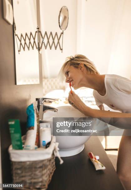 disabled woman holds a toothbrush with her foot and brushes them - robe tube stock pictures, royalty-free photos & images