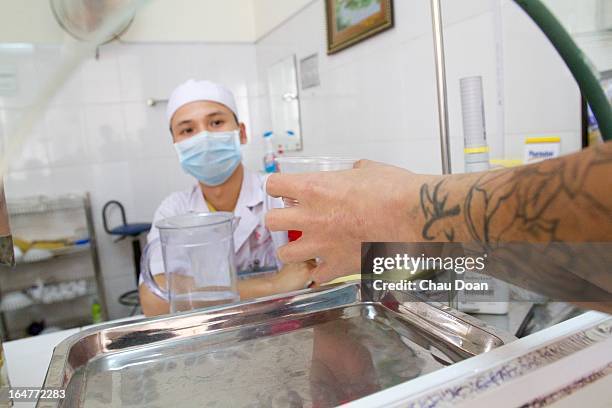 Health worker gives drug addicts their daily methadone dose at the Long Bien District Health Center. Vietnam has many comprehensive health programs...