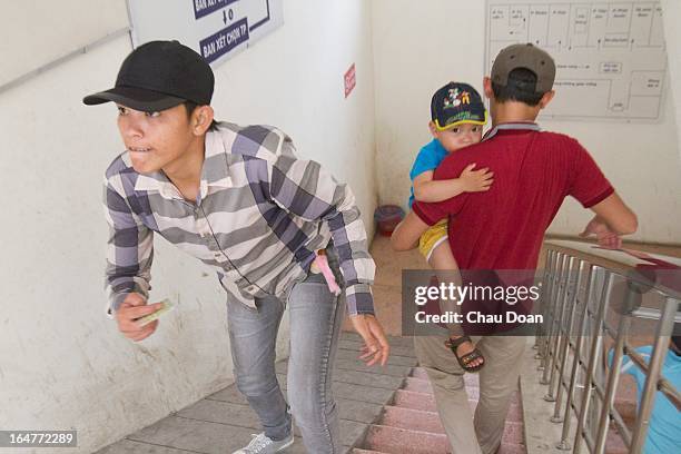 Drug addict leaves with his son after getting his daily methadone dose at the Long Bien District Health Center. Vietnam has many comprehensive health...