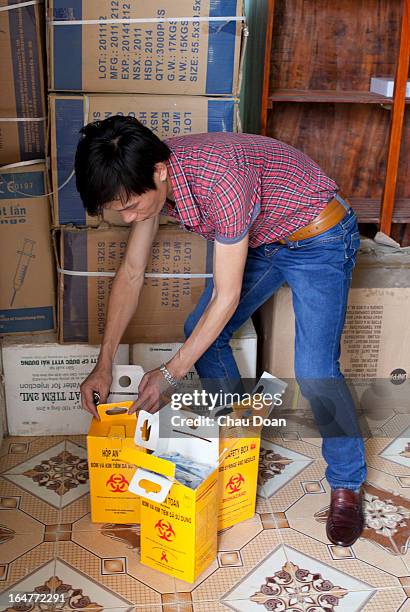 Health worker packs up boxes of used syringes and needles, returned by drug addicts, are prepared for safe destruction at the center for health...