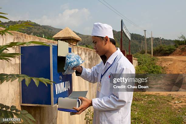 Health worker who works for the Quai Cang commune health clinic in To district, Dien Bien puts syringes and needles into a box where drug addicts can...