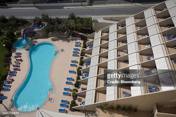 Visitors bathe at the poolside at the luxury five star St Raphael resort hotel in Limassol, Cyprus, on Wednesday, March 27, 2013. Directly or...