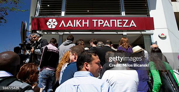 People gather in front of Laiki Bank as the country's banks re-open following 12 days of closure on March 28, 2013 in Nicosia, Cyprus. Bank trading...