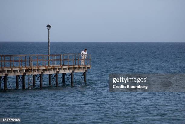Tourist looks out from a pontoon towards the Mediterranean sea in Limassol, Cyprus, on Wednesday, March 27, 2013. The ECB said on March 25 it won't...