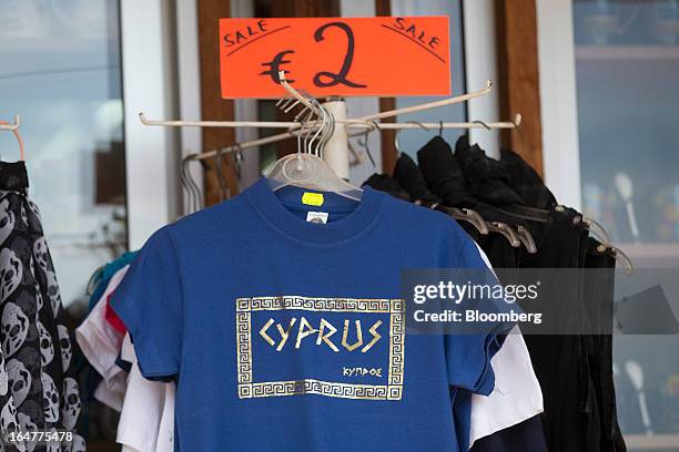 Souvenir t-shirts stand for sale beneath a two euro price sign outside a tourist store in Limassol, Cyprus, on Wednesday, March 27, 2013. The ECB...