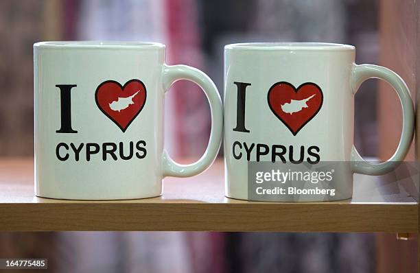 Souvenir mugs decorated with "I love Cyprus" designs stand for sale in a tourist store in Limassol, Cyprus, on Wednesday, March 27, 2013. The ECB...