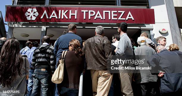 People gather in front of Laiki Bank as the country's banks re-open following 12 days of closure on March 28, 2013 in Nicosia, Cyprus. Bank trading...