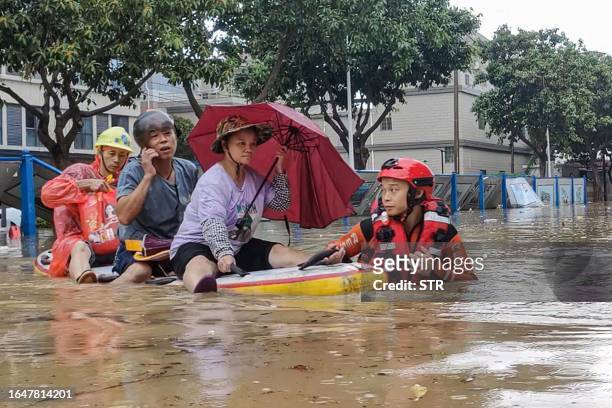 Rescue personnel evacuate residents from a flooded area following heavy rains caused by Typhoon Haikui in Xiamen, in China's southern Fujian province...