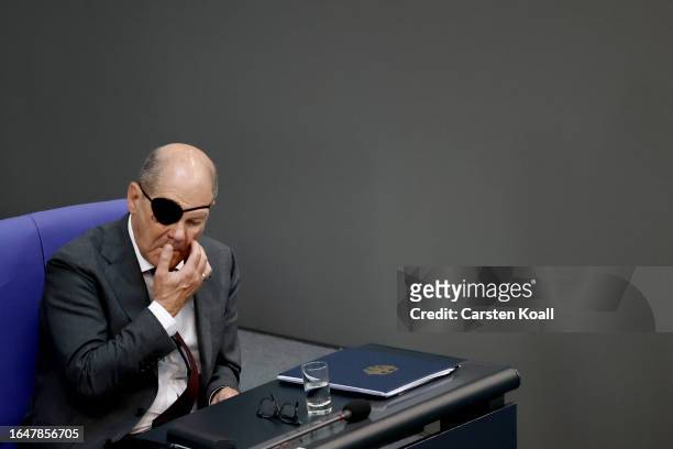 German Chancellor Olaf Scholz attends debates at the Bundestag over the 2024 federal budget wearing an eye patch due to a recent accident while...