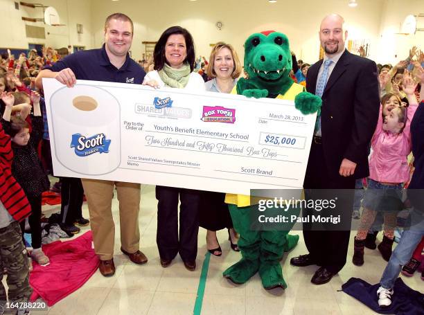Scott Brand Manager Ben Johnson presents a $25,000 check to Box Tops Coordinator Jenn Stump, PTA President Laura Runyeon, Mascot Al E. Gator and...