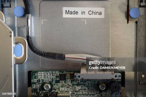 This picture taken on March 28, 2013 in Rennes, western France shows a sticker reading ''Made in China'' on a computer's motherboard. AFP PHOTO...