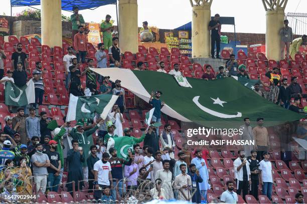 Pakistan's fans hold national flags as they cheer during the Asia Cup 2023 one-day international cricket match between Pakistan and Bangladesh at the...