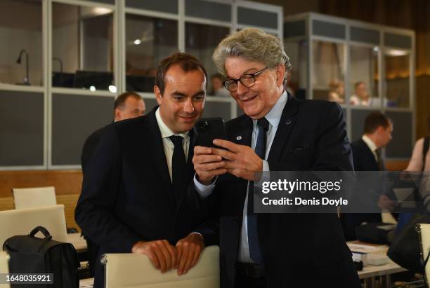 Thierry Breton , European Union Commissioner looks at his phone beside Sebastien Lecornu, French Defence Minister prior to the informal meeting of EU...