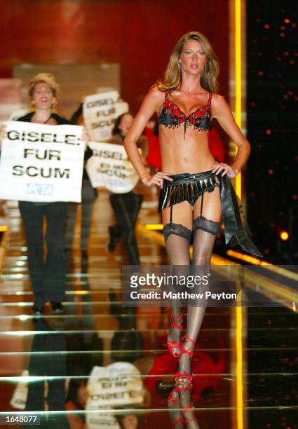Model Gisele Bundchen walks the runway while activists for the PETA, People for the Ethical Treatment of Animals, protest at the Victoria Secret...