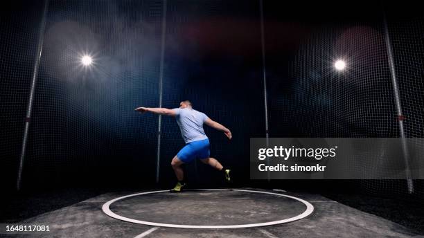 male athlete turning with discus - discus stock pictures, royalty-free photos & images