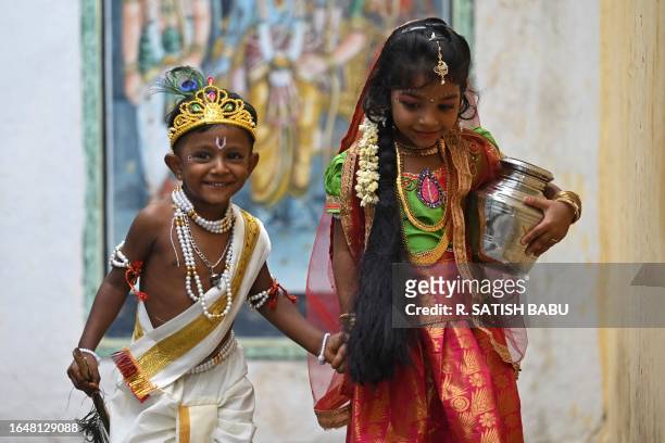 Children dressed as Hindu god Krishna and his consort Radha, take part in the celebrations on the eve of Janmashtami festival, which marks the birth...