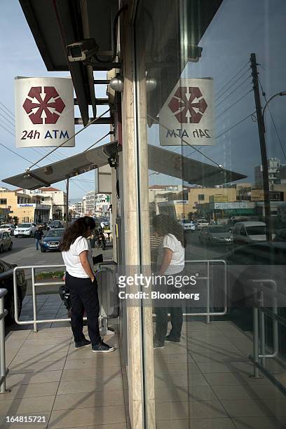 Customer uses an automated teller machine at a branch of Cyprus Popular Bank Pcl, also known as Laiki Bank as banks open for the first time in two...
