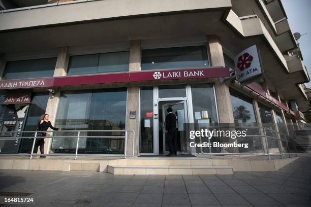 Man enters a branch of Cyprus Popular Bank Pcl, also known as Laiki Bank, as banks open for the first time in two weeks in Nicosia, Cyprus, on...