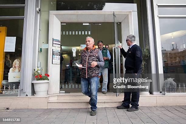 Customers exit a Bank of Cyprus Plc branch as banks open for the first time in two weeks in Nicosia, Cyprus, on Thursday, March 28, 2013. The Central...