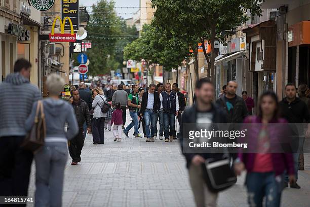 Pedestrians walk down Ledra Street in Nicosia, Cyprus, on Thursday, March 28, 2013. The Central Bank of Cyprus's capital controls will include a...