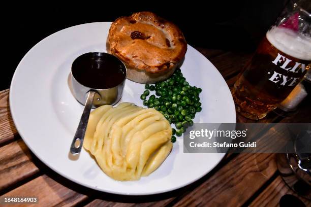 Close Up of the typical dish English Meat Pie with mashed potatoes and boiled peas inside a pub on August 23, 2023 in London, England. London is the...