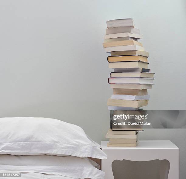 pile of books on a bedside table. - bedside table stock pictures, royalty-free photos & images