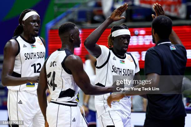 Nuni Omot of South Sudan celebrates with head coach Royal Ivey , Deng Acuoth and Dut Jok Kacuol of South Sudan after sinking a three-pointer to end...