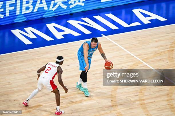 Slovenia's Luka Doncic and Canada's Shai Gilgeous-Alexander vie for the ball during the FIBA Basketball World Cup quarter-final match between Canada...