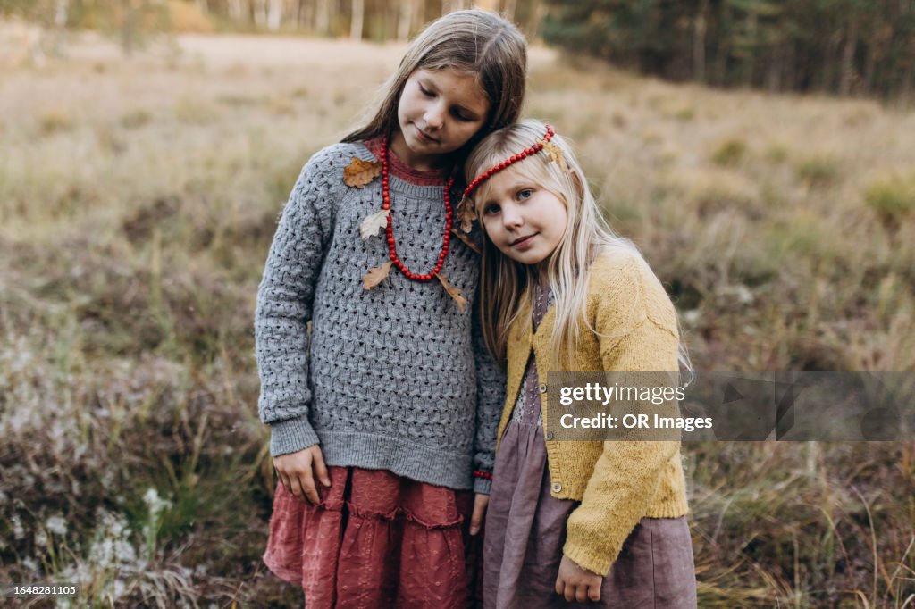 Portrait of two girls standing on a remote meadow
