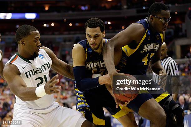 Erik Swoope of the Miami Hurricanes fights for the loose ball against Jake Thomas and Chris Otule of the Marquette Golden Eagles during the East...