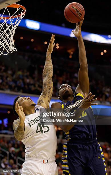 Chris Otule of the Marquette Golden Eagles shoots the ball over Julian Gamble of the Miami Hurricanes during the East Regional Round of the 2013 NCAA...