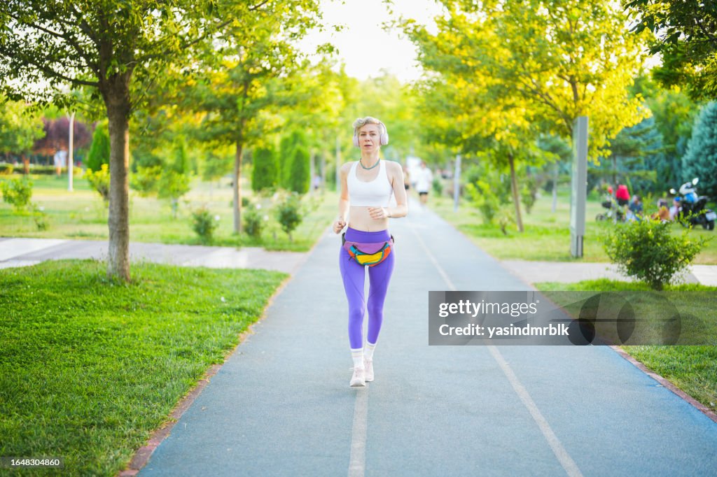 Fit athletic short hair woman jogging in the park