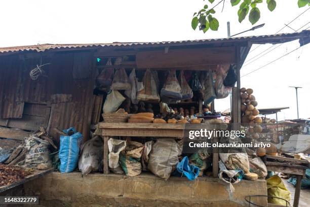 traditional herbs and calabash seller in ajina market, ikorodu, lagos nigeria - nigeria city stock pictures, royalty-free photos & images