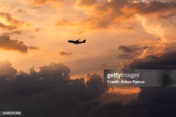 airplane at sunset above the storm clouds. - clouds from aircraft point of view stock pictures, royalty-free photos & images