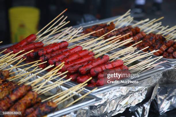 Pork and chicken skewers and sausages at a food stall during the Taste of Manila Food Festival in Toronto, Ontario, Canada, on August 20, 2023. The...