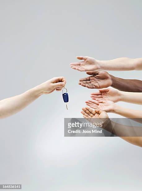 hand holding car key, multiple hands receiving - economía colaborativa fotografías e imágenes de stock