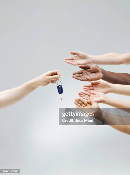 hand holding car key, multiple hands receiving - sharing economy stockfoto's en -beelden