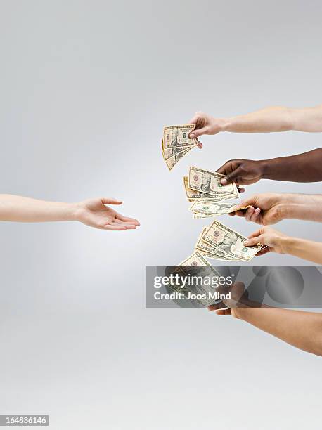 hands holding out money, one hand receiving - crowdfunding stock-fotos und bilder