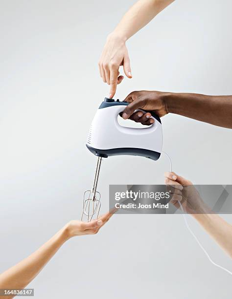 multiple hands holding a mixer - sharing economy stockfoto's en -beelden