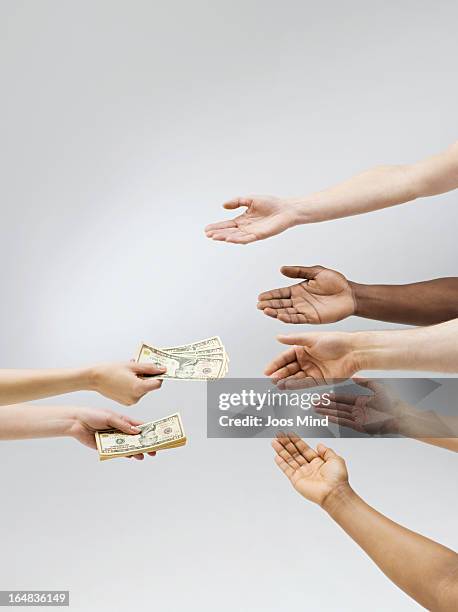 hand holding out money, multiple hands receiving - giving hands stock pictures, royalty-free photos & images