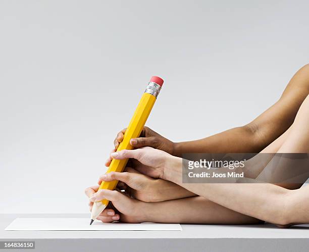 multiple hands all writing with one pen - überzeugen stock-fotos und bilder