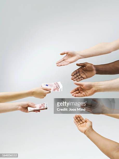 hand holding out money, multiple hands receiving - ethnicity stock-fotos und bilder