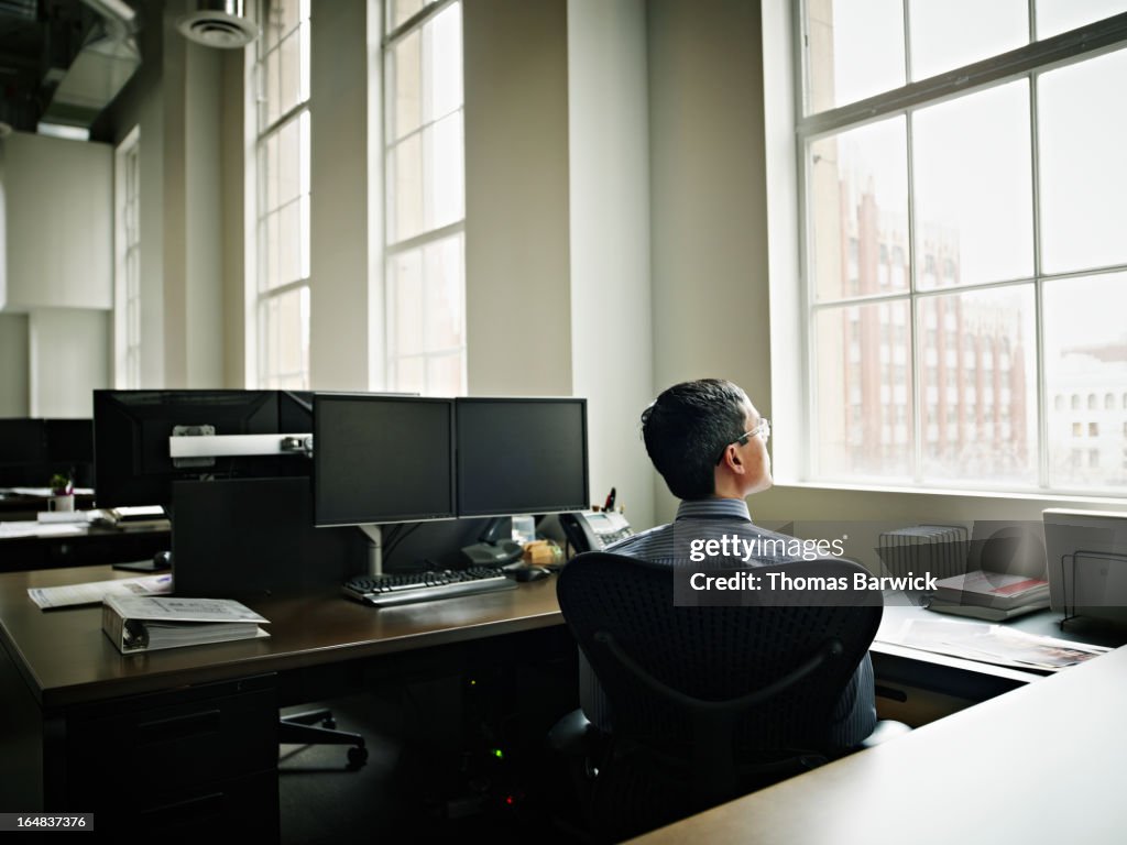 Businessman looking out window at cityscape