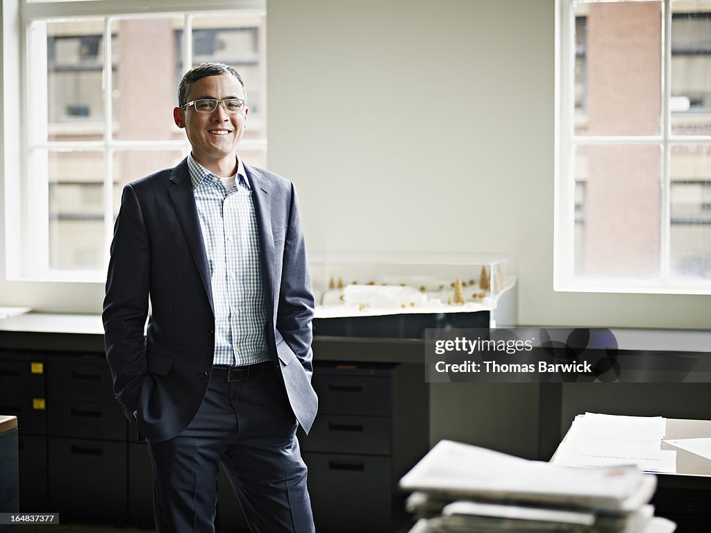 Smiling businessman standing in architects office